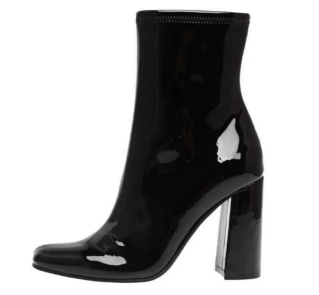 Black patent chunky heel ankle boot on white background.
