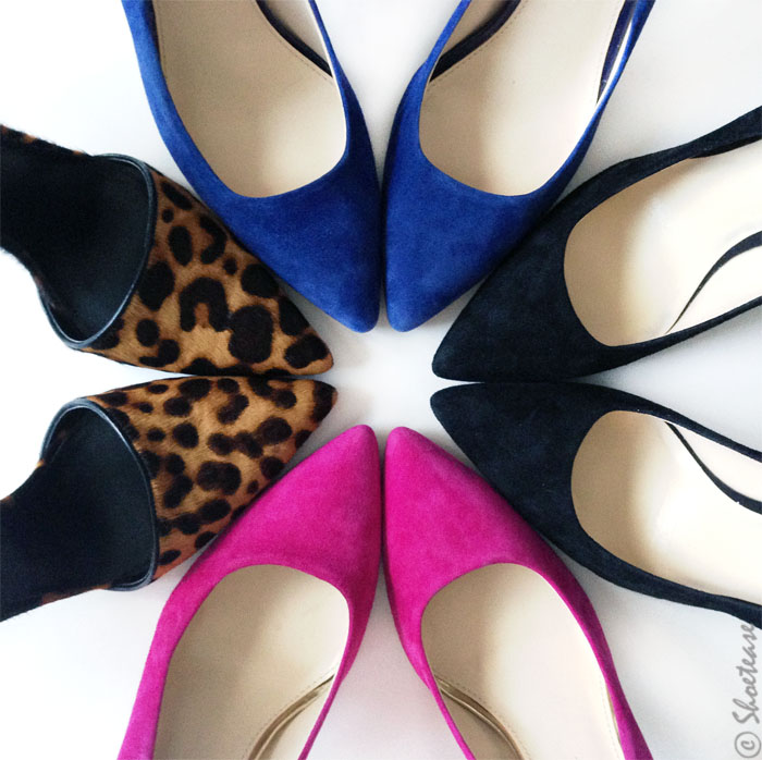 Close up of pointed toe pumps in pink, black, blue and leopard print in a circle on the floor.