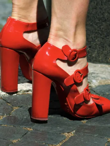 Close up of woman's feet wearing red shoes with high heels.