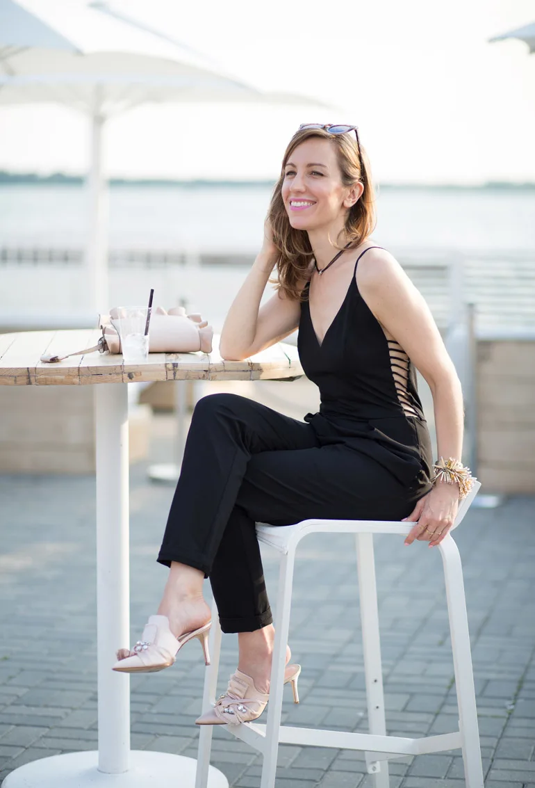 Lady sitting wearing Mule shoes to wear with jumpsuit blush accessories