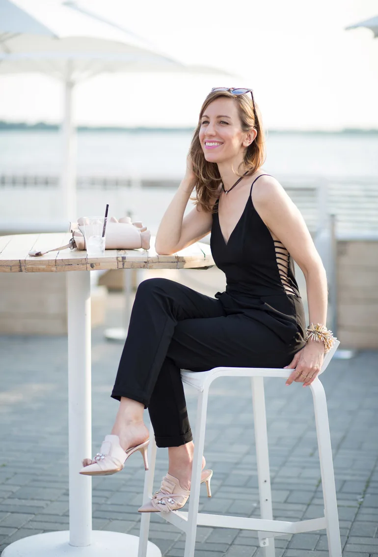 A guest wears Chanel earrings, a white pantsuit with flowing wide-leg