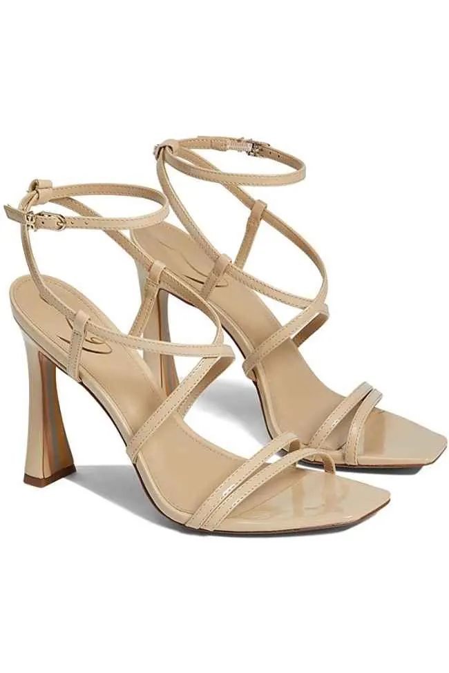Patent beige leather stiletto sandals with ankle straps.