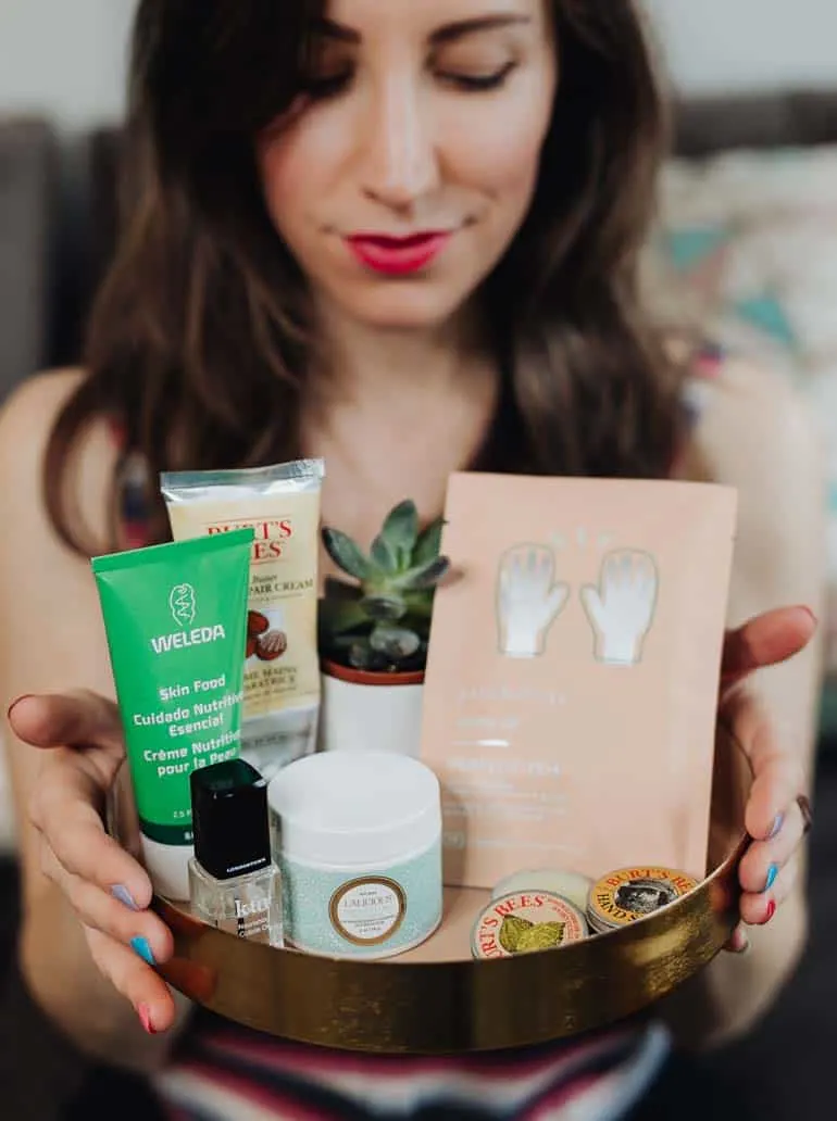 Close up of woman holding tray filled with moisturizing hand creams and products to cure dry hands and feet.
