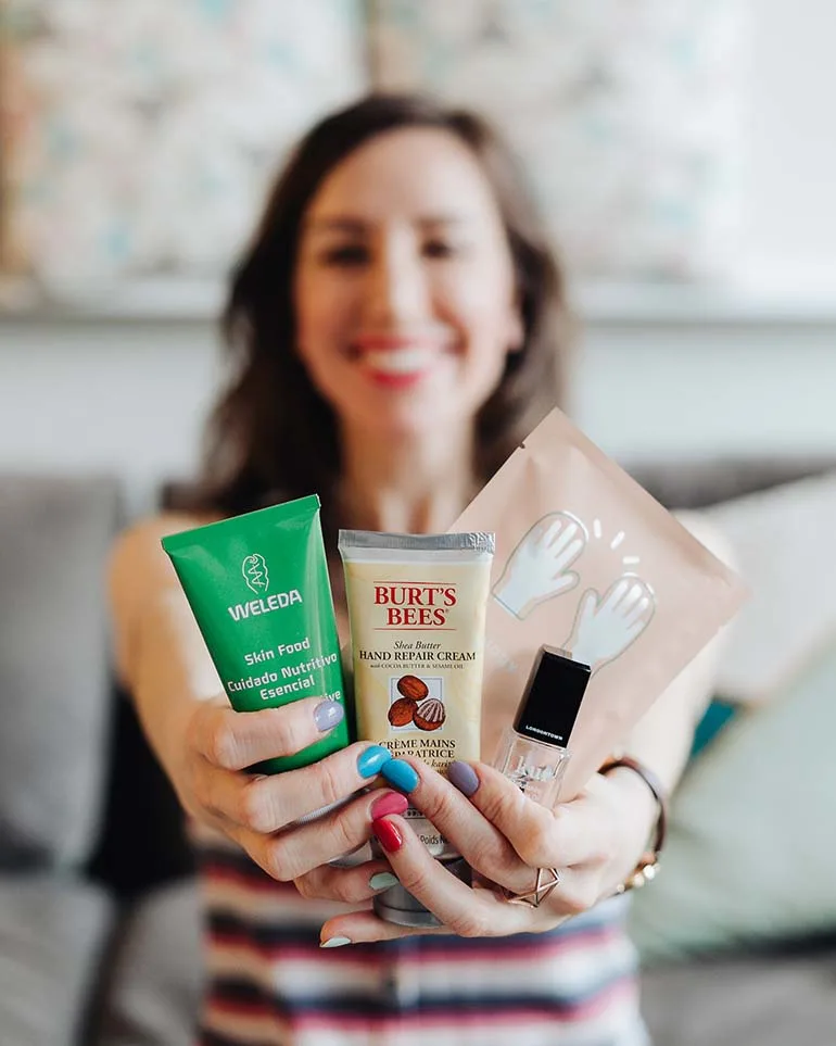 Close up of woman extending hands and holding tray filled with moisturizing hand creams and products to cure dry hands and feet.