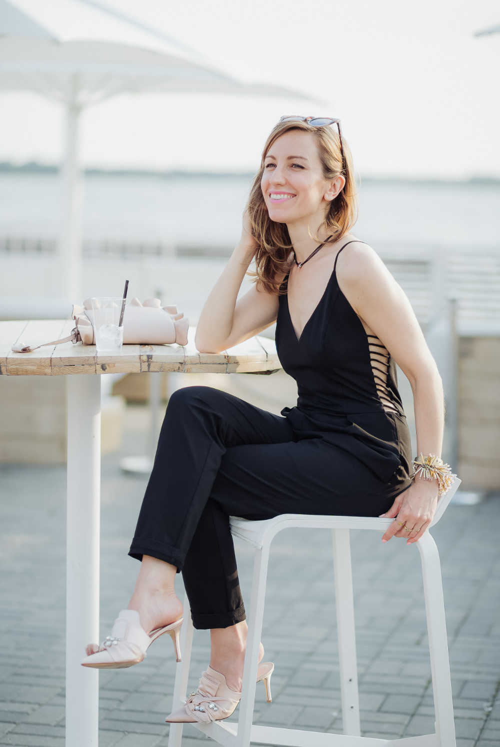 Lady sitting wearing Mule shoes to wear with jumpsuit blush accessories