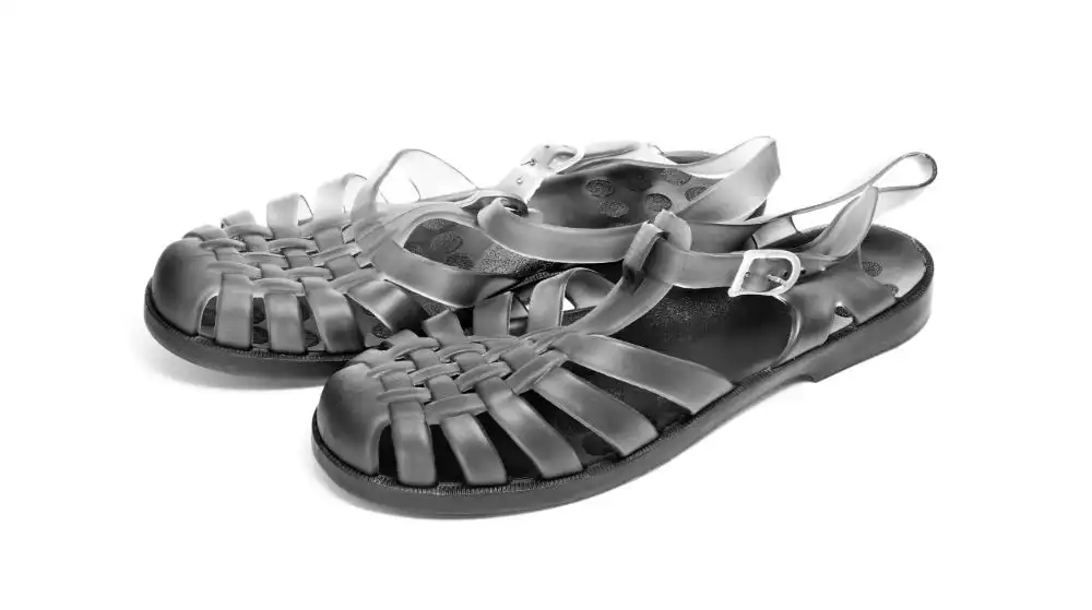 A pair of black jelly sandals on a white background.