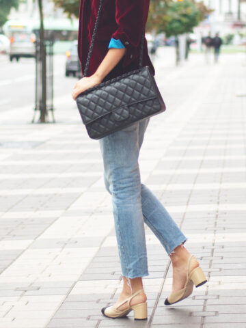 What shoes to wear with straight leg jeans with Side view of woman in jeans and jacket on street with bag.