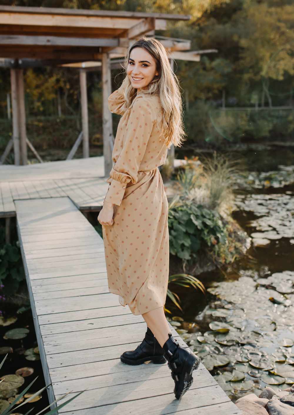 Woman wearing black combat boots with beige summer dress.