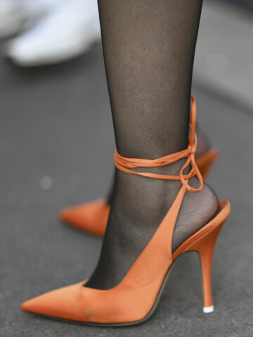 Close up of woman in orange shoes with scuff marks.