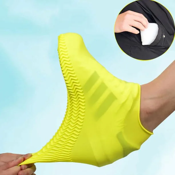 Close up of yellow waterproof silicone shoe cover over adidas sneaker being pulled on by a hand. 