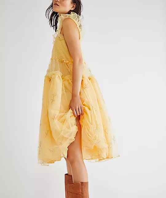 Woman wearing yellow Tulle dress with cowboy boots.