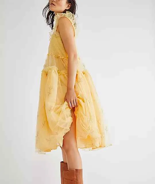 Woman wearing yellow Tulle dress with cowboy boots.
