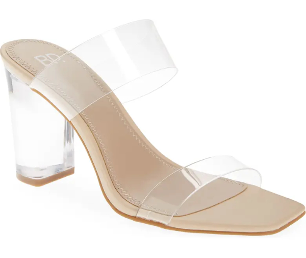 Clear strap sandals with clear lucite heel on beige page on white background.
