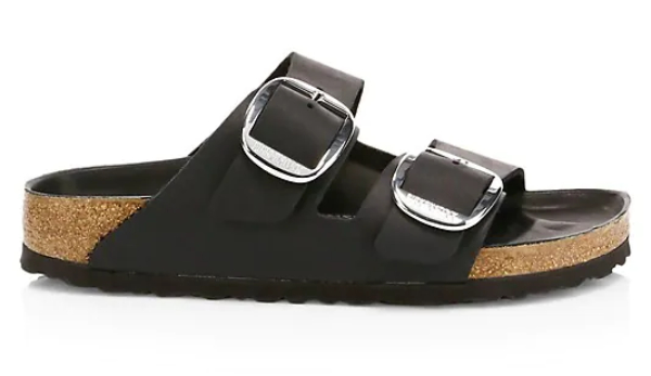 Black birkenstock sandals with silver buckles and cork sole on white background.