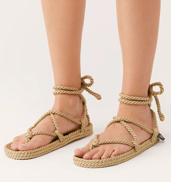 Cropped view of woman's feet wearing waraji sandals laced with tan rope. 