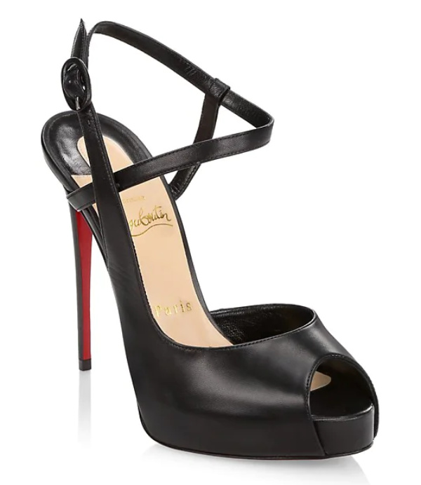 Black peep toe sandals with ankle strap and red bottoms by christian louboutin on white background.