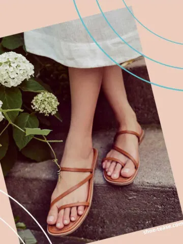 Close up of woman's feet on stairs wearing brown strappy slides outfit with white dress hem next to white flowers.