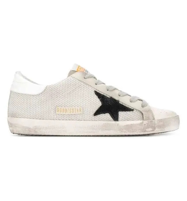  One white Golden Goose super star sneakers with black star sneakers on white background.