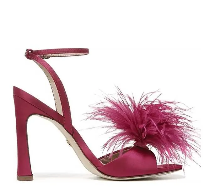 Hot pink high heel sandals with ankle strap and front feather detail on white background.