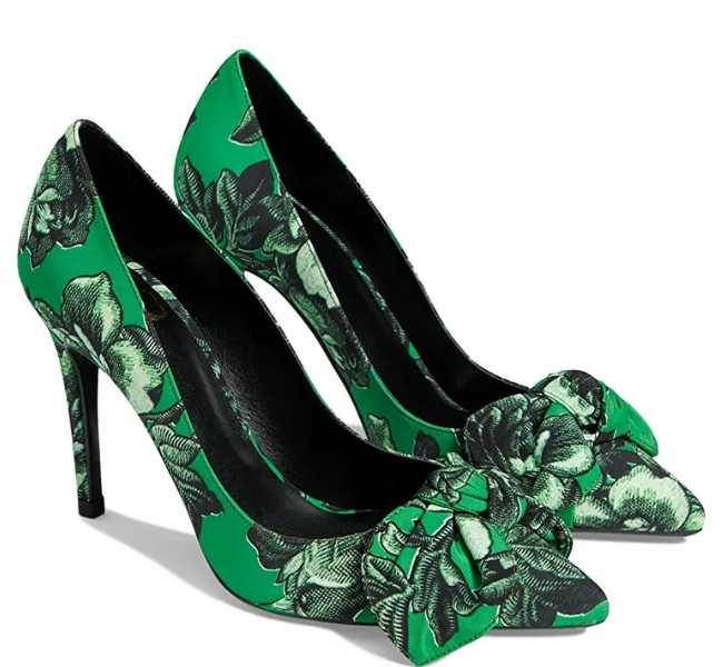 Pair of green bow non traditional wedding heels on white background.