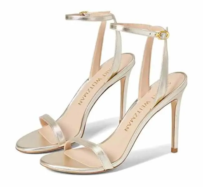 Gold strappy stiletto sandals on a white background.