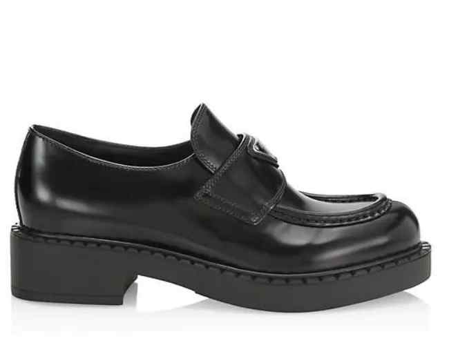Black leather round toe loafers on white background.