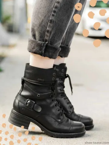 Cropped view of woman's feet wearing Taos crave combat boots in black waterproof with cuffed grey ankle boots on a sidewalk.