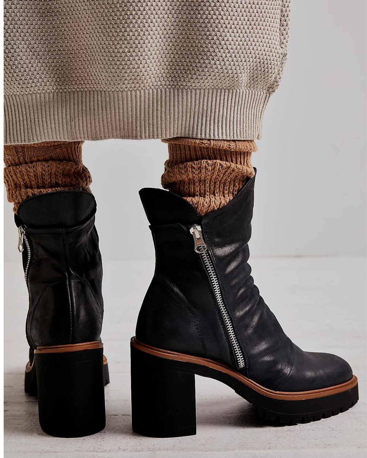 Close up of woman wearing tan slouchy socks with ankle boots.