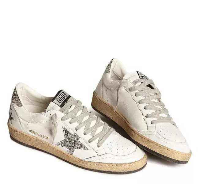 White with silver star design lace up sneakers on white background.