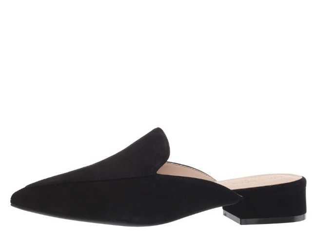 Black suede slip on pointed toe mule on white background.