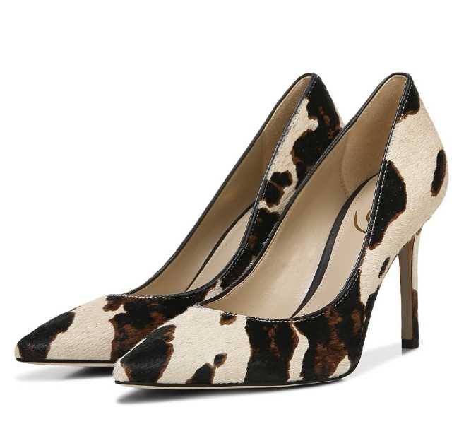 Cow print pumps on white background.