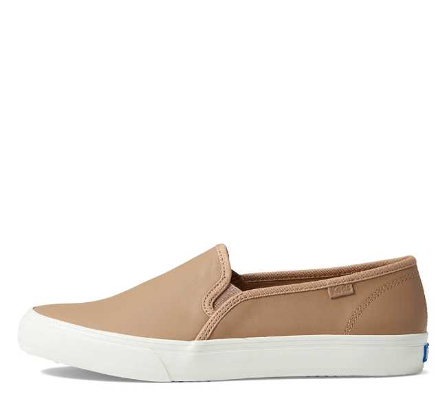 Tan leather upper white rubber sole slip on sneaker on white background.