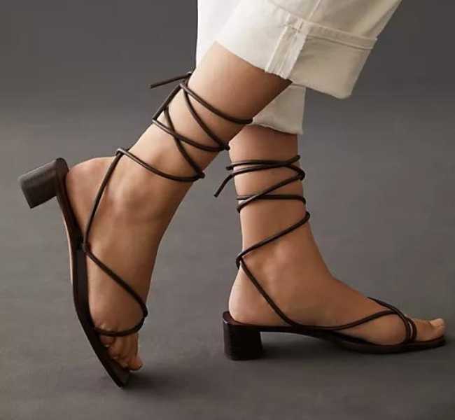 Dark brown leather straps wooden heel tie style heel on white background.