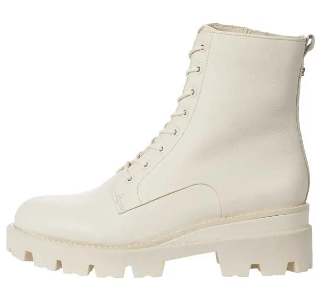 White lace up combat boot on white background.