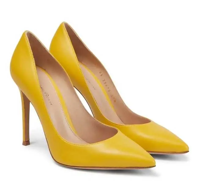 Yellow leather heeled pumps on white background.
