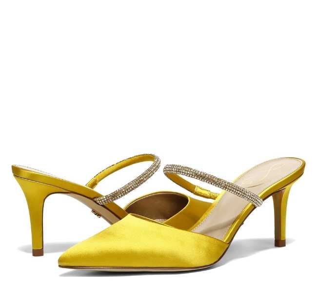 Yellow pointed toe slip on glitter embellished strap heels on white background.