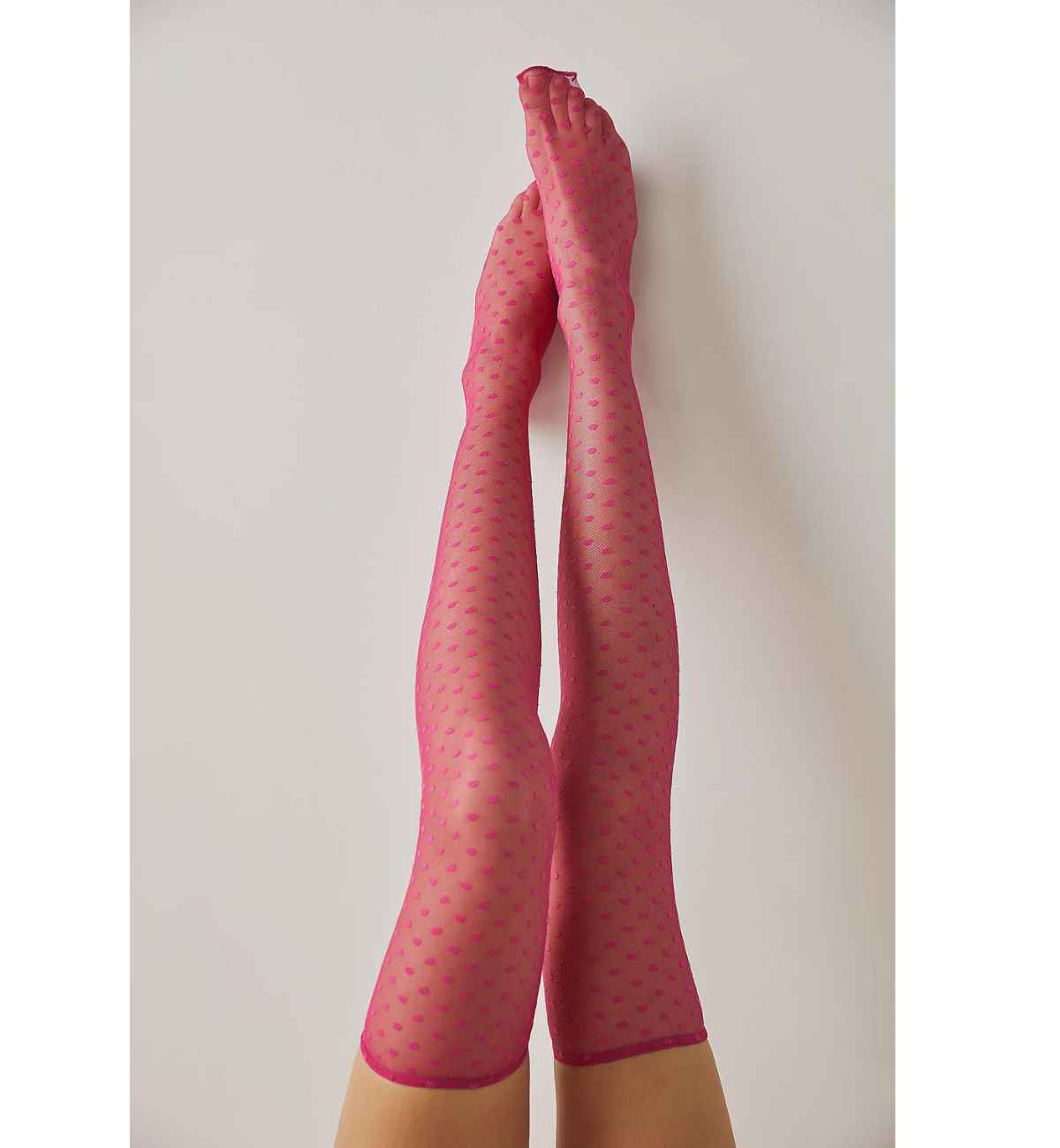 Women wearing pink thigh high heart socks with heart pattern all over on beige background.