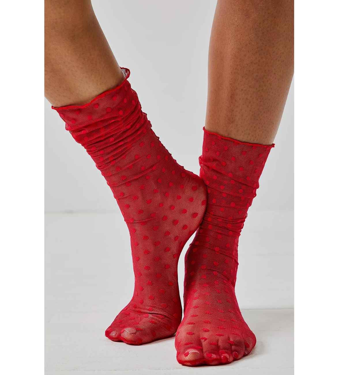 Women wearing red heart socks with polkadot pattern all over on white background.