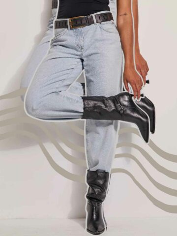 Cropped image of woman wearing light jeans with boots, holding the heel, with wave graphic behind her.
