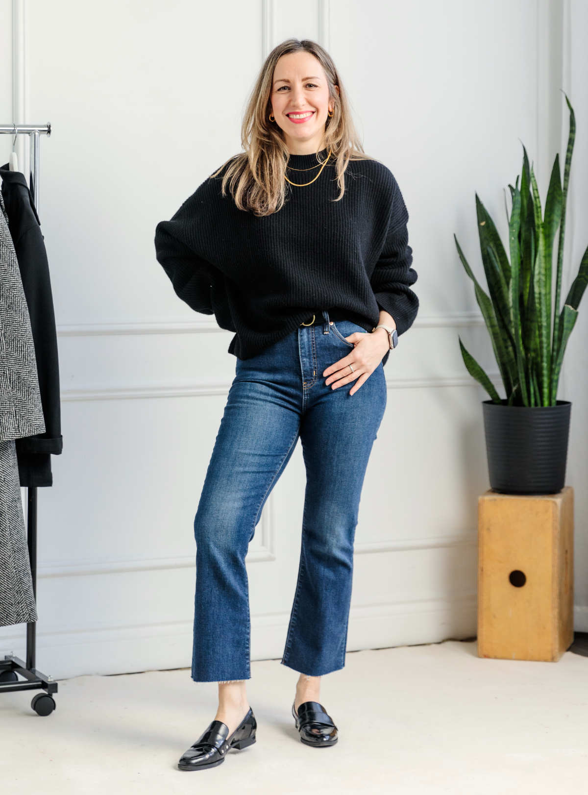 Woman wearing kick flare jeans with black loafers and sweater.