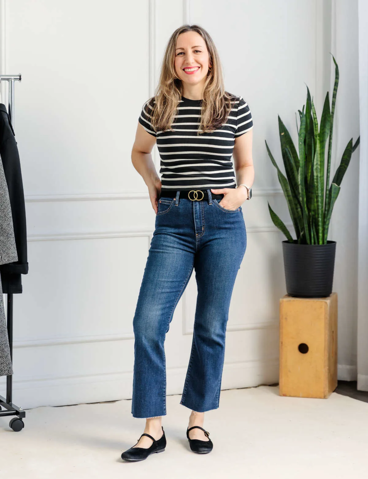 Woman wearing kick flare jeans with Mary Jane flats and black and white stripe tee shirt.