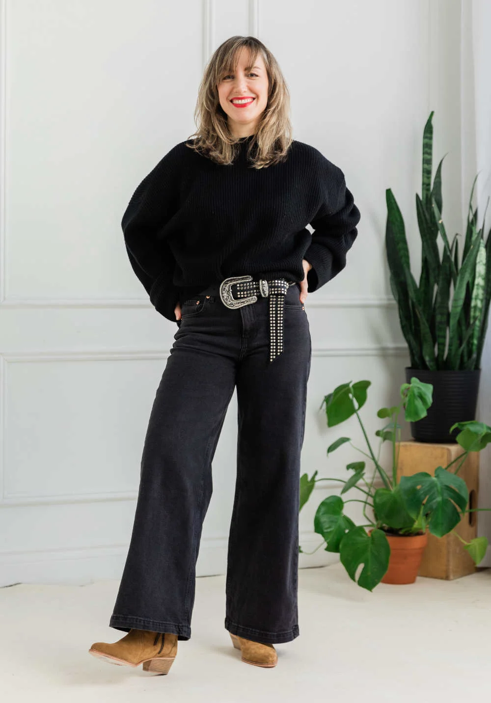 Woman wearing wide leg jeans outfit with western boots.