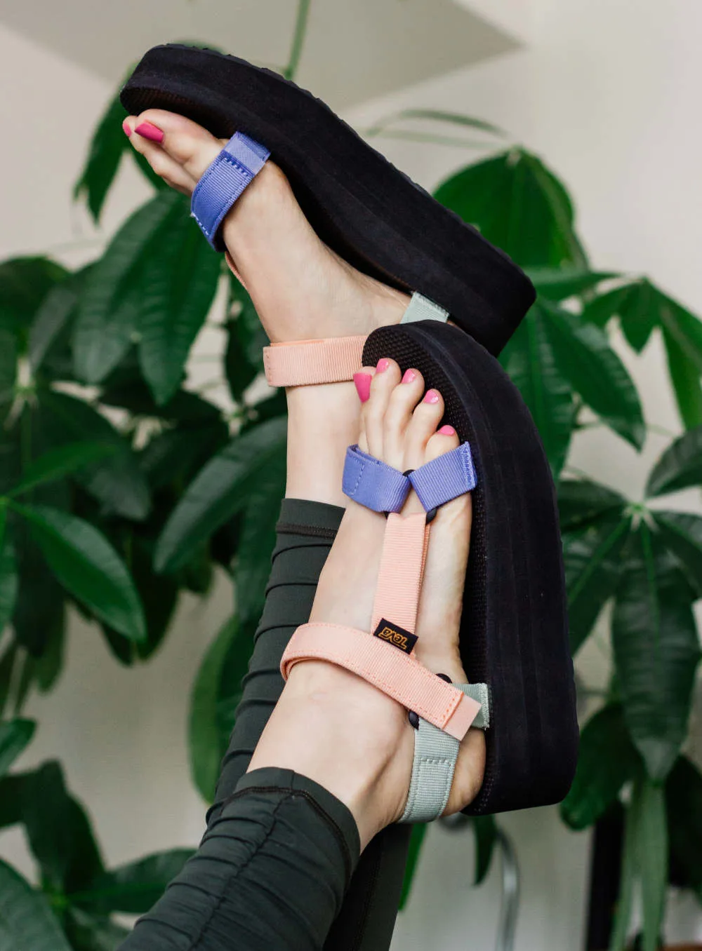Close up of woman wearing colorful Teva Platform Sandals.